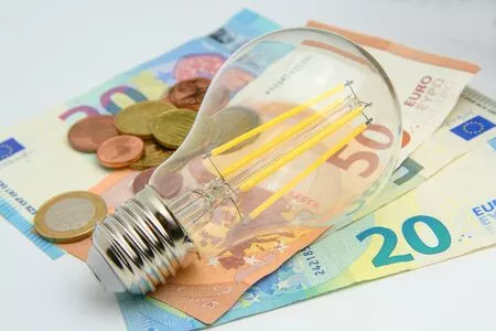 Glühbirne auf Euro Scheinen und Münzen Glühbirne auf Euro Scheinen und Münzen
